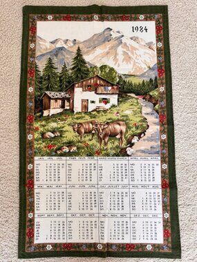 Vintage 1984 Alpine scene calendar tea towel featuring a cozy house, mountains,